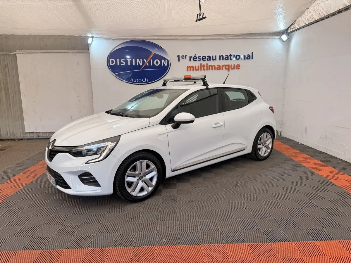 Renault Clio Business E-Tech hybride blanc vue 3/4 avant droit en intérieur avec toit équipé d'une rampe lumineuse.