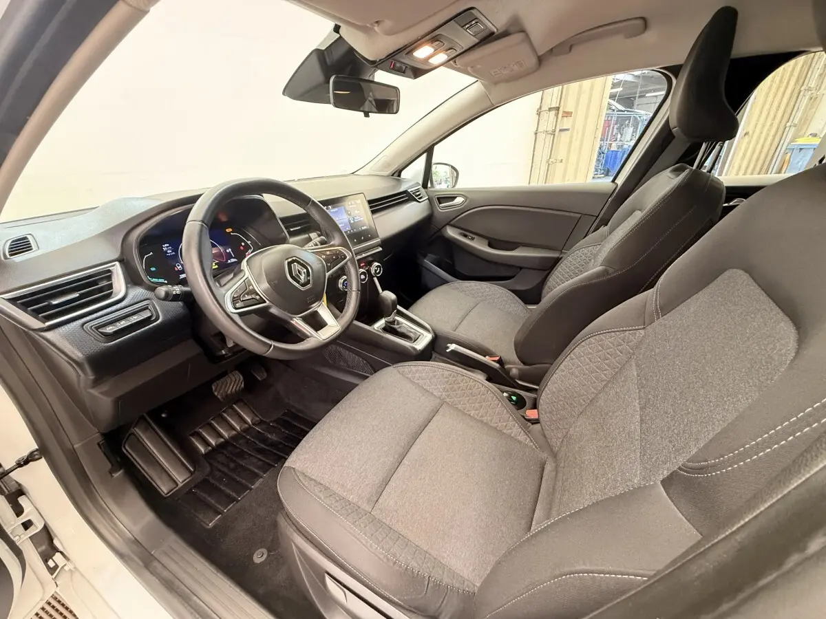 Vue intérieure côté conducteur de la Renault Clio Business E-Tech hybride 2022, sièges gris et volant multifonctions cuir synthétique.