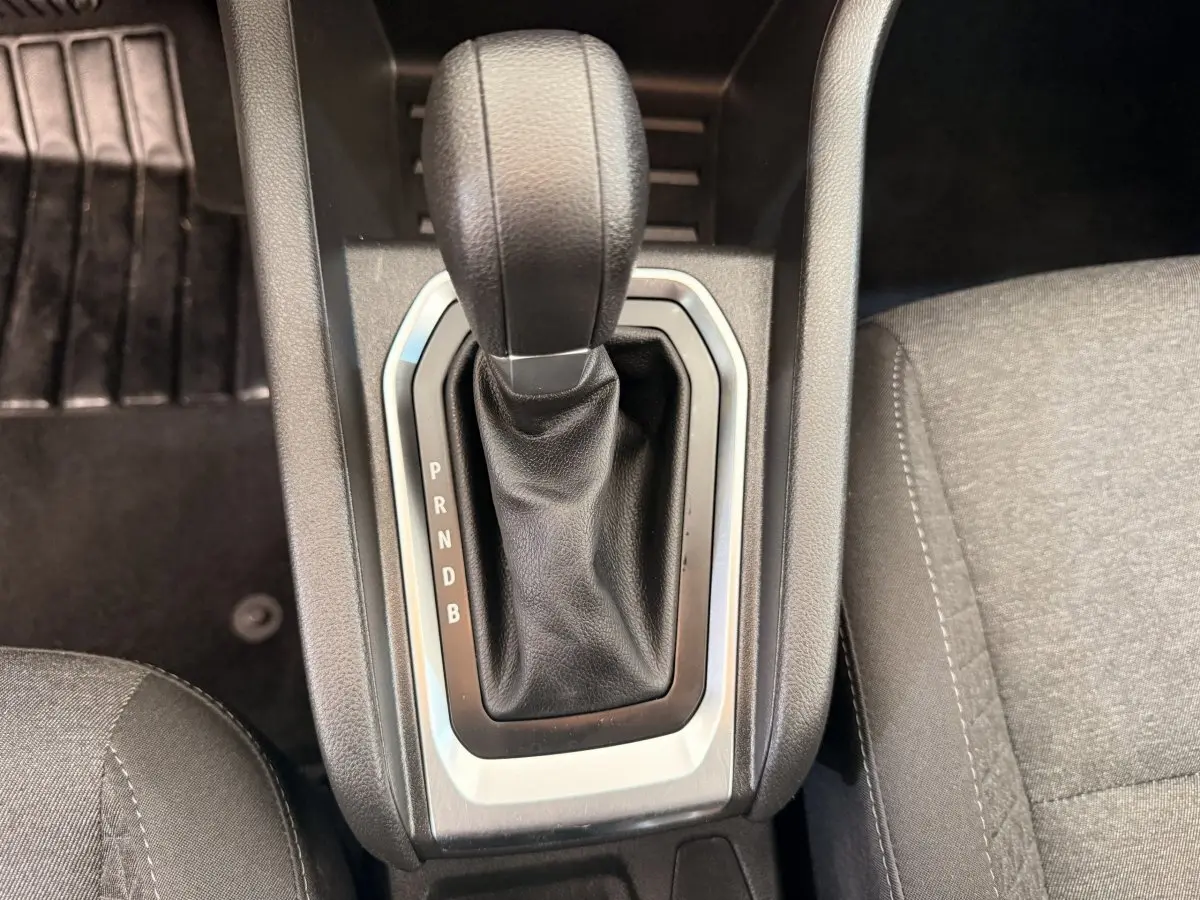 Gros plan sur la commande de la boîte automatique noire de la Renault Clio Business E-Tech hybride 2022, intérieur gris.