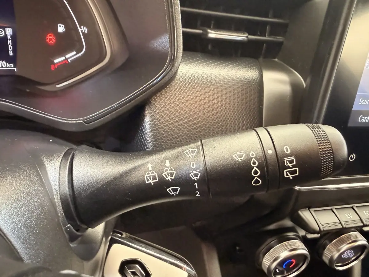 Gros plan sur la manette d’essuie-glace côté gauche du tableau de bord d’une Renault Clio Business E-Tech blanche 2022.