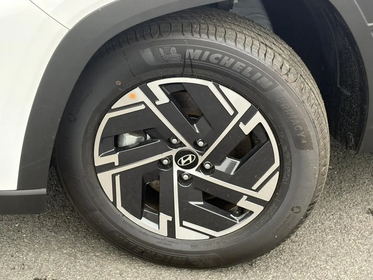 Gros plan sur la jante alliage 17'' noire et argentée du Hyundai Tucson blanc Atlas, avec pneu Michelin visible.