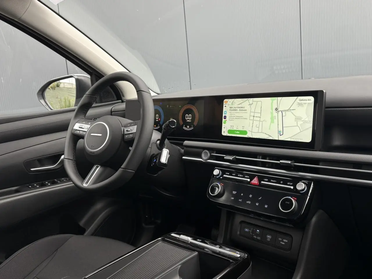 Vue intérieure côté conducteur du Hyundai Tucson 2026, tableau de bord moderne avec écran tactile large et volant multifonction.