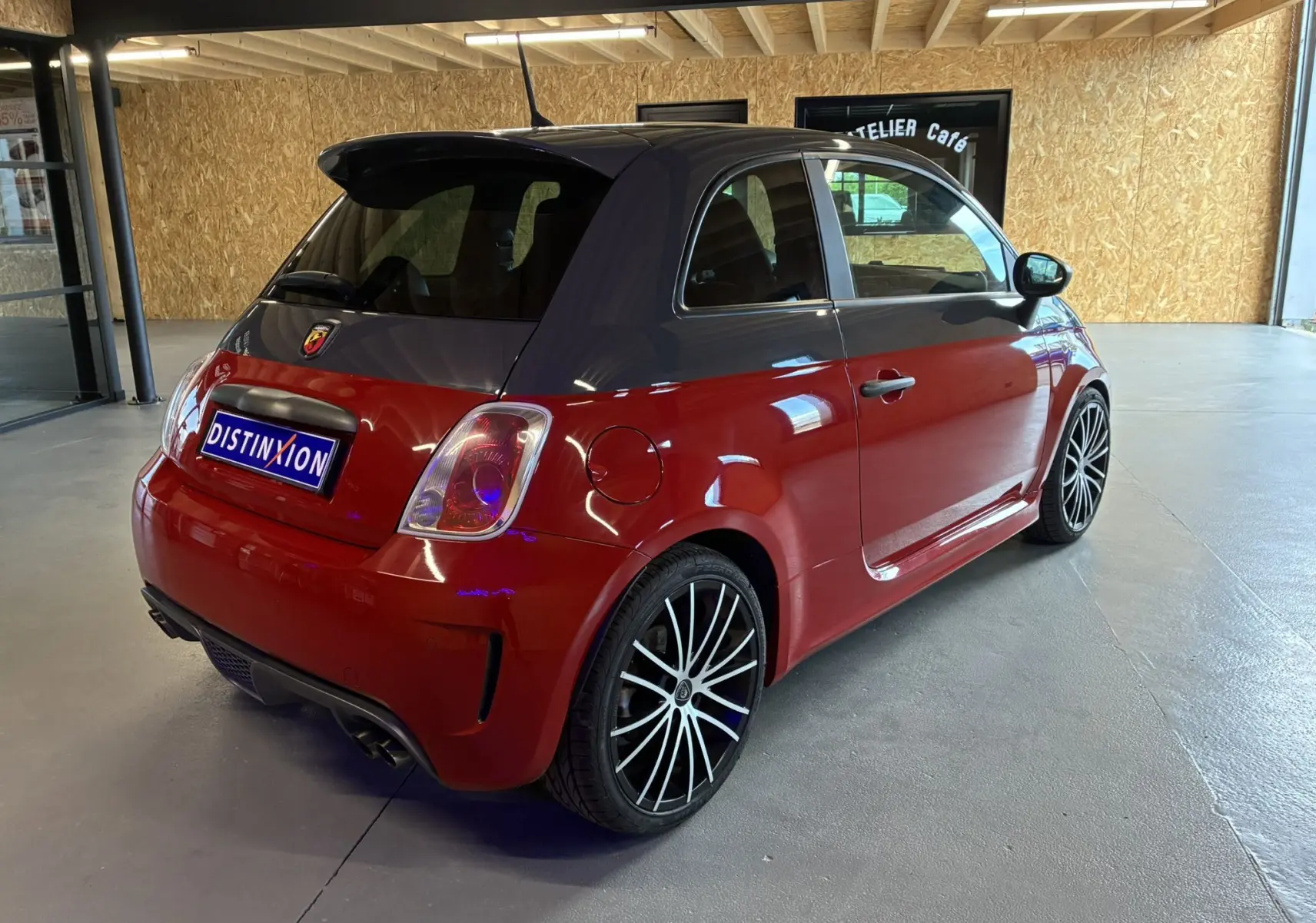 Vue 3/4 arrière droite de l'Abarth 500 Competizione rouge avec toit noir et jantes sport multibranches.
