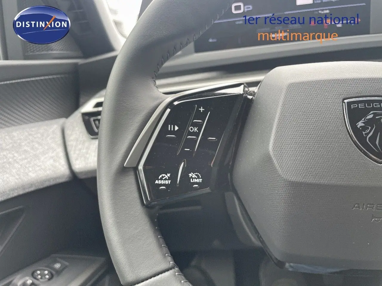 Gros plan sur le volant cuir noir du Peugeot 5008 2025 avec commandes d'assistance et limiteur visibles.