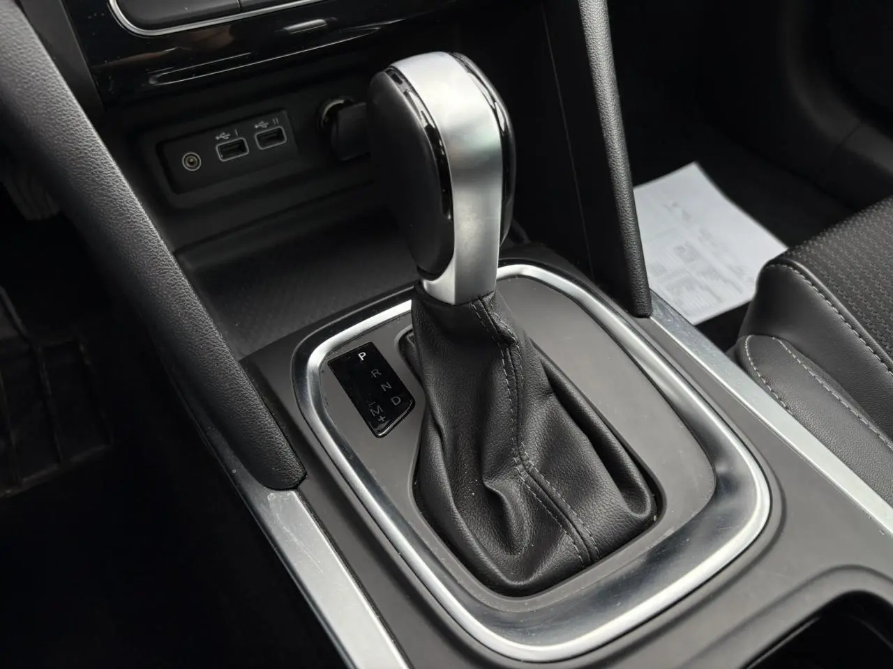 Le levier de vitesses automatique en cuir noir et métal dans la console centrale d'une Renault Mégane Break 2024.