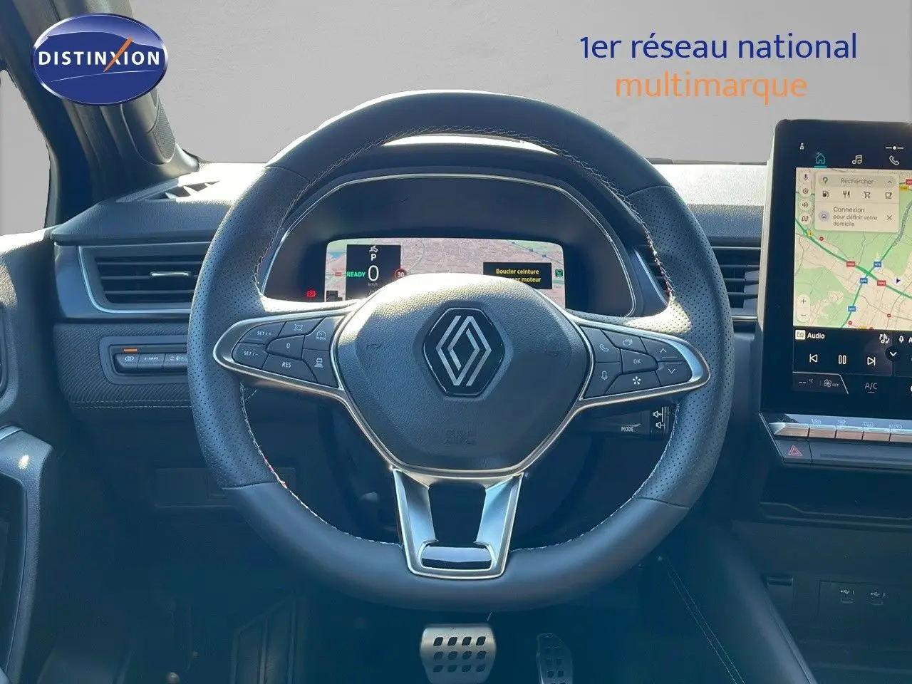 Vue rapprochée du volant et tableau de bord numérique du Renault Captur E-Tech hybride 2025, intérieur moderne noir.