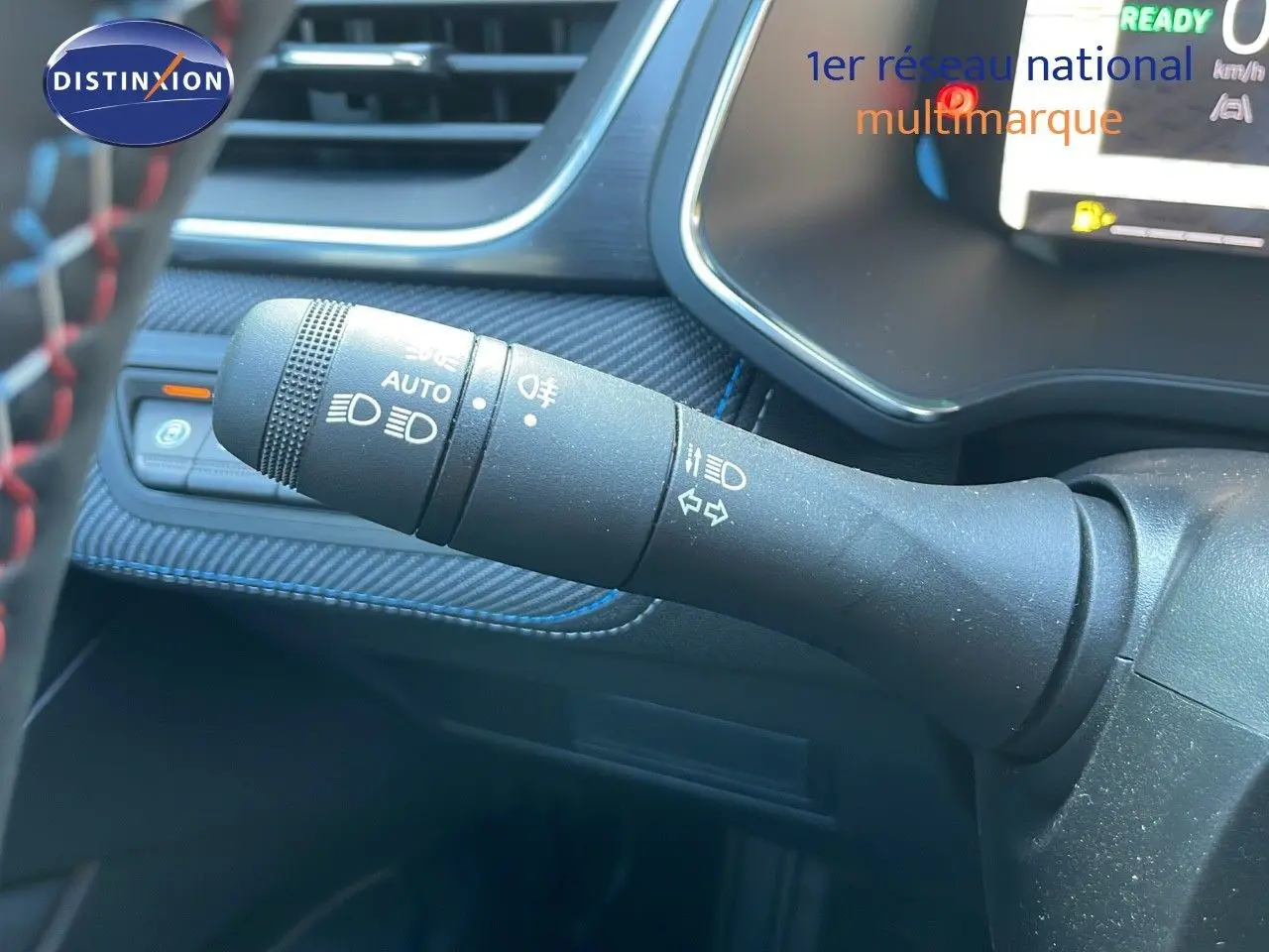Gros plan sur la commande des feux et clignotants du tableau de bord du Renault Captur E-Tech hybride 2025 bleu iron metal.