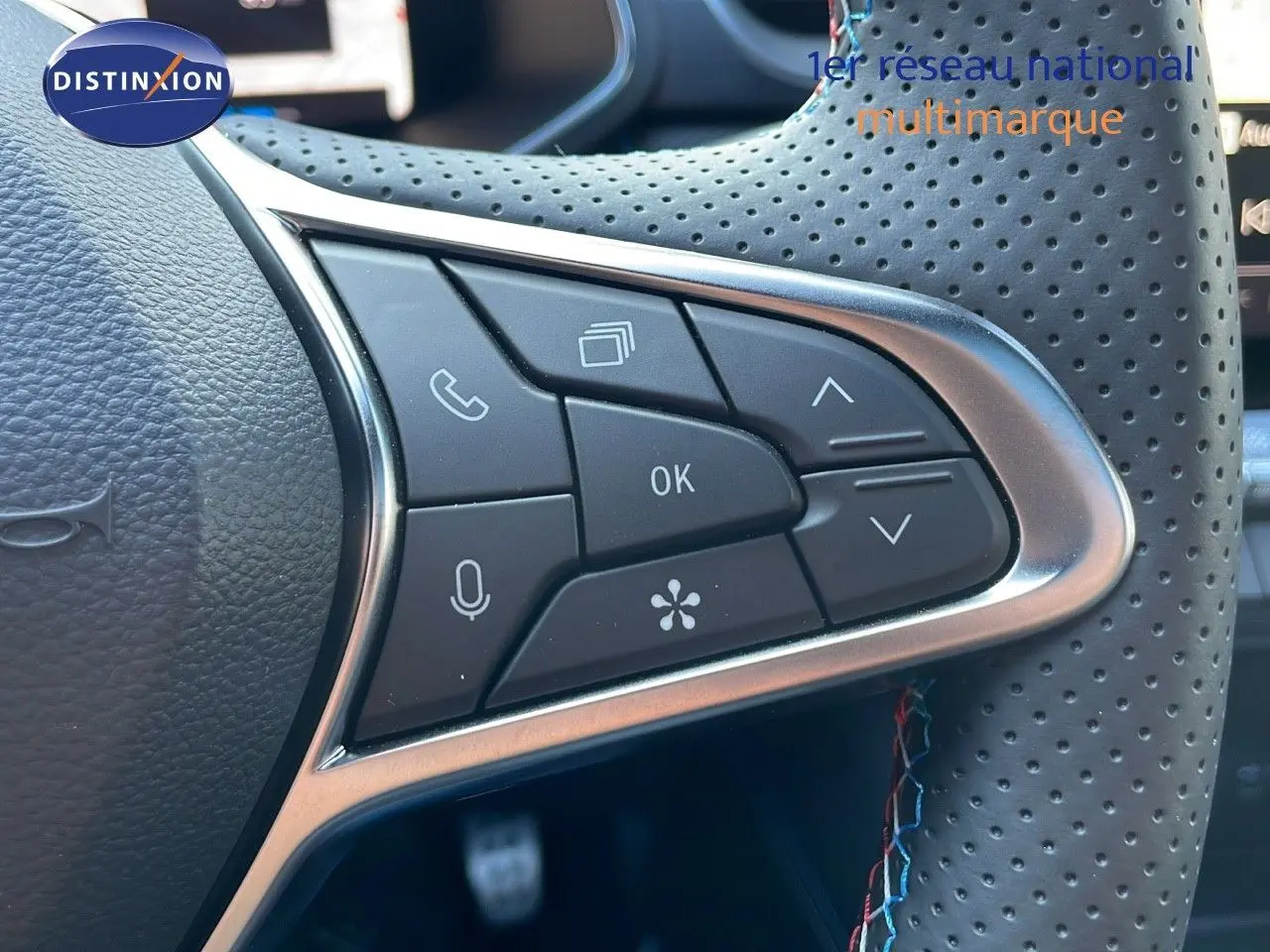 Gros plan sur les commandes multifonctions du volant en cuir perforé du Renault Captur E-Tech hybride 2025.