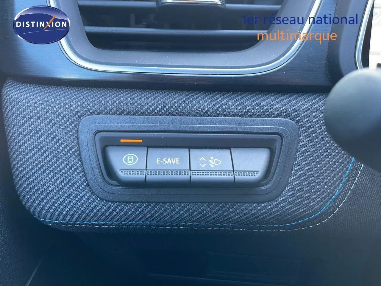 Gros plan sur les commandes E-SAVE et réglage des phares du tableau de bord du Renault Captur E-Tech hybride 2025.