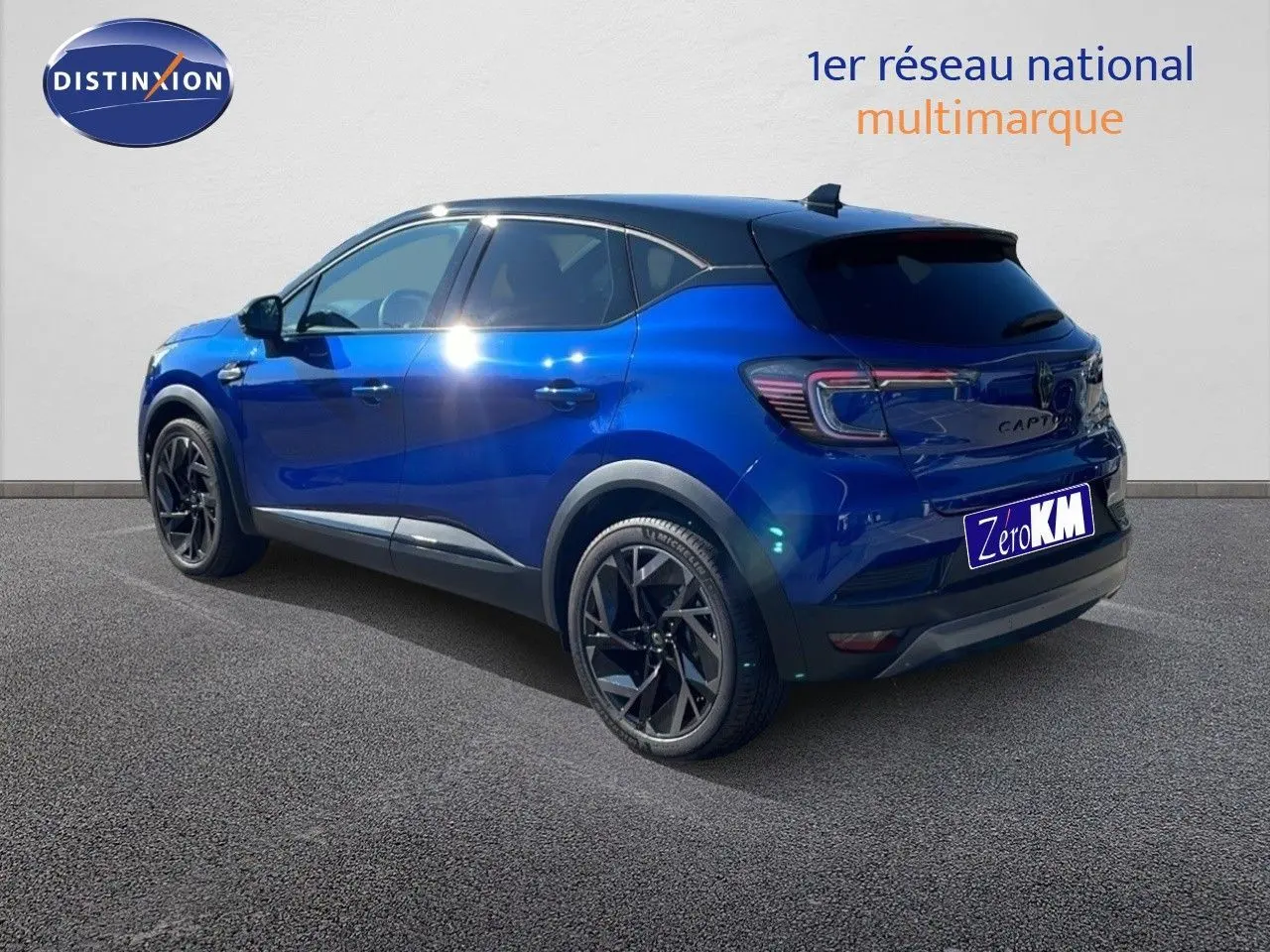 Renault Captur E-Tech hybride 2025 bleu Iron Metal avec toit noir, vue 3/4 arrière côté gauche sur fond neutre.
