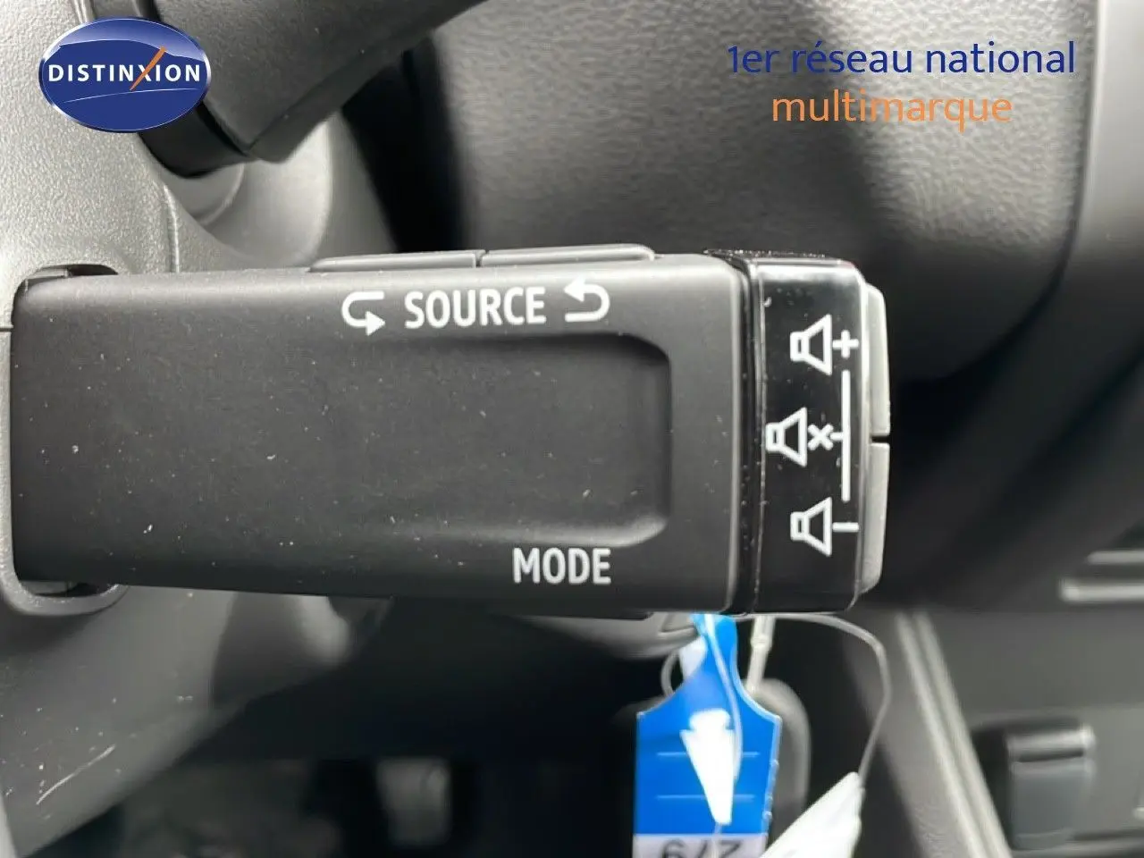 Gros plan sur la commande au volant du Renault Captur 2025 noir étoile métal, avec boutons source et mode visibles.