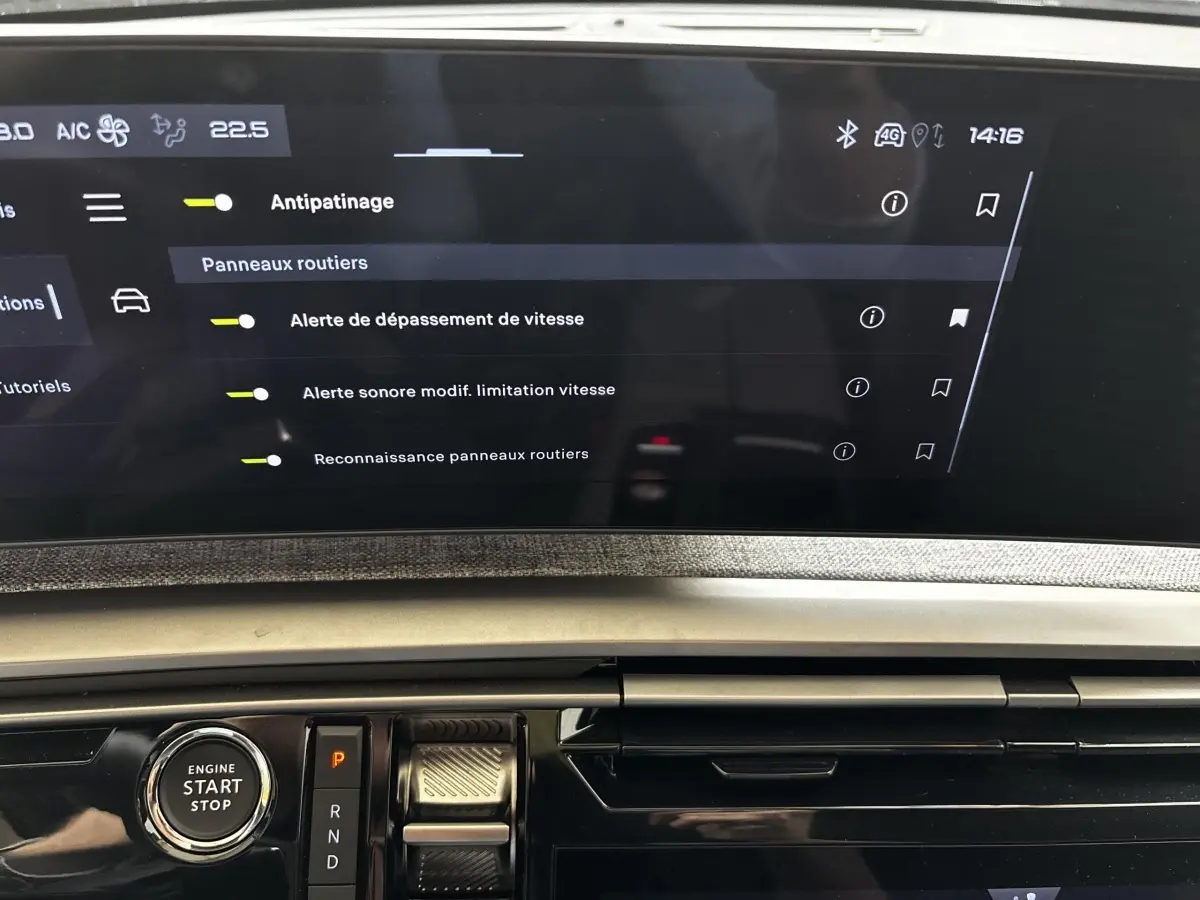 Gros plan sur la console centrale et l’écran tactile du Peugeot 5008 gris clair, affichant les réglages d’aide à la conduite.