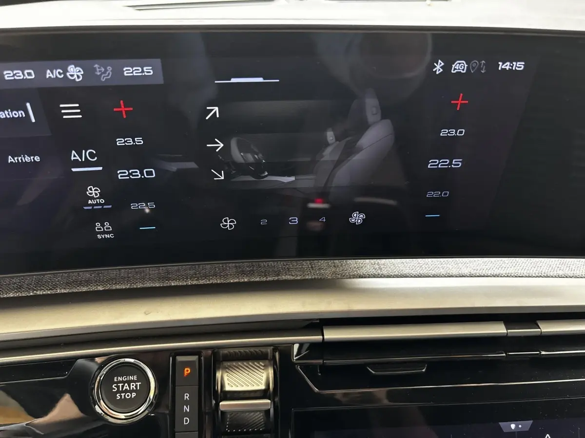 Vue rapprochée du tableau de bord tactile et bouton démarrage du Peugeot 5008 gris clair, version hybride 2025.