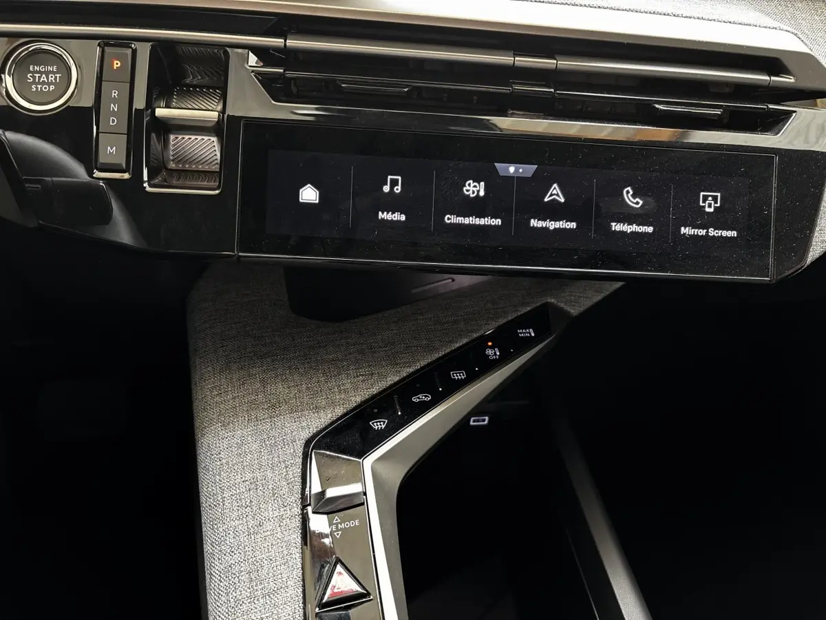 Vue rapprochée de la console centrale et écran tactile du Peugeot 5008 gris clair, avec bouton start et commandes climatisation.