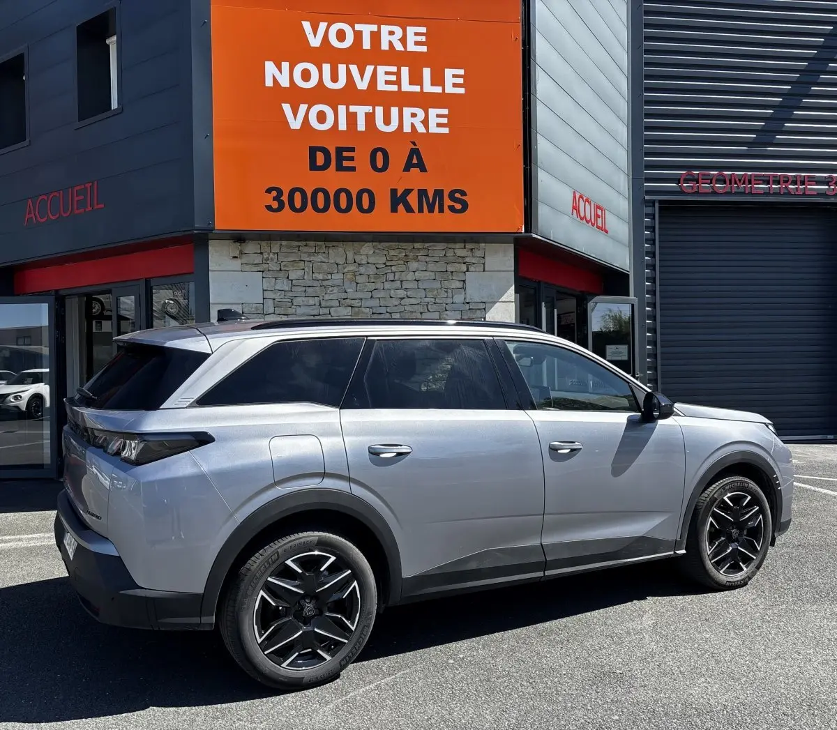 Peugeot 5008 gris clair vue de profil droit, SUV hybride avec jantes noires et vitres teintées.