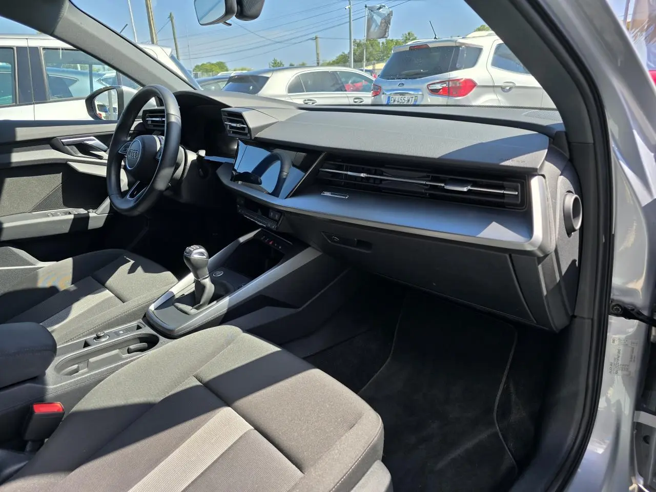 Intérieur de l'Audi A3 Sportback 2022 vu côté passager, tableau de bord moderne et volant cuir noir.