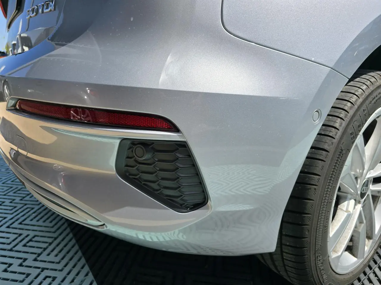 Gros plan sur le coin arrière droit gris argent d’une Audi A3 Sportback 30 TDI avec feu arrière et jante alliage 17 pouces.