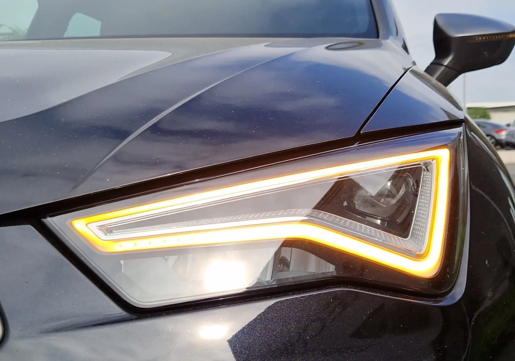 Gros plan sur le phare avant droit allumé d’un SEAT Ateca noir 2023, soulignant son design LED distinctif.