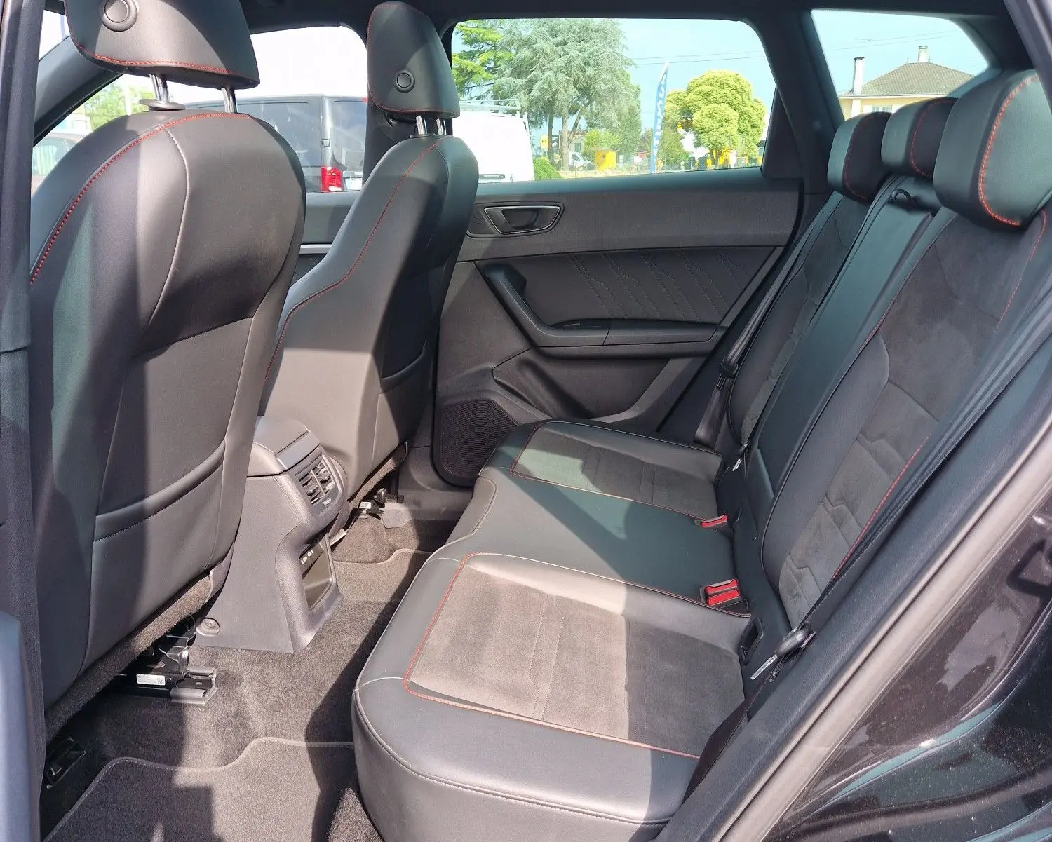 Vue intérieure côté droit des sièges arrière en cuir noir avec surpiqûres rouges et toit panoramique du SEAT Ateca 2.0 TDI 2023.