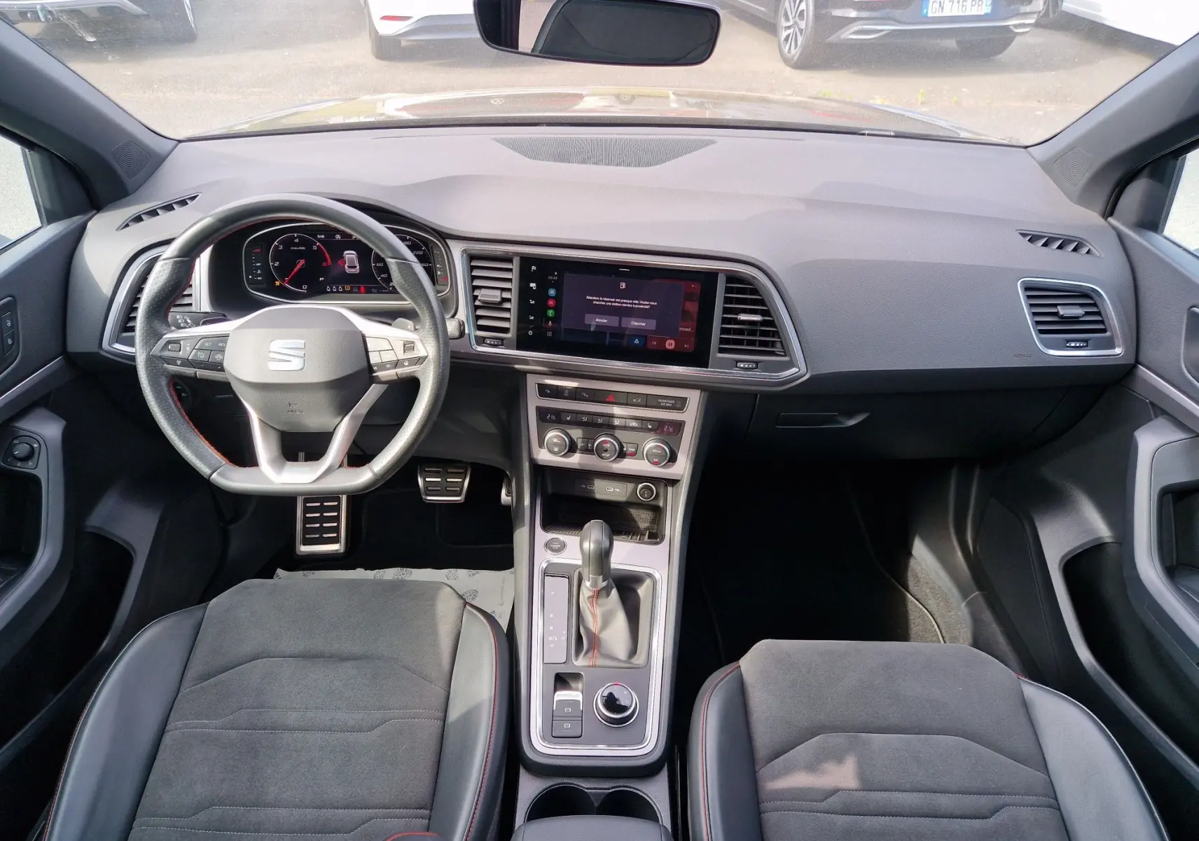 Vue intérieure avant du tableau de bord et volant du SEAT Ateca 2023, avec écran tactile et boîte automatique.