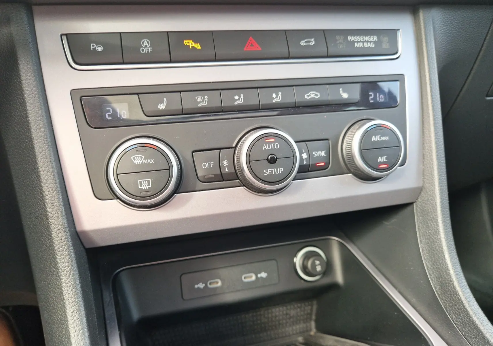 Gros plan sur la console centrale du SEAT Ateca 2023, montrant les commandes de climatisation et les ports USB.