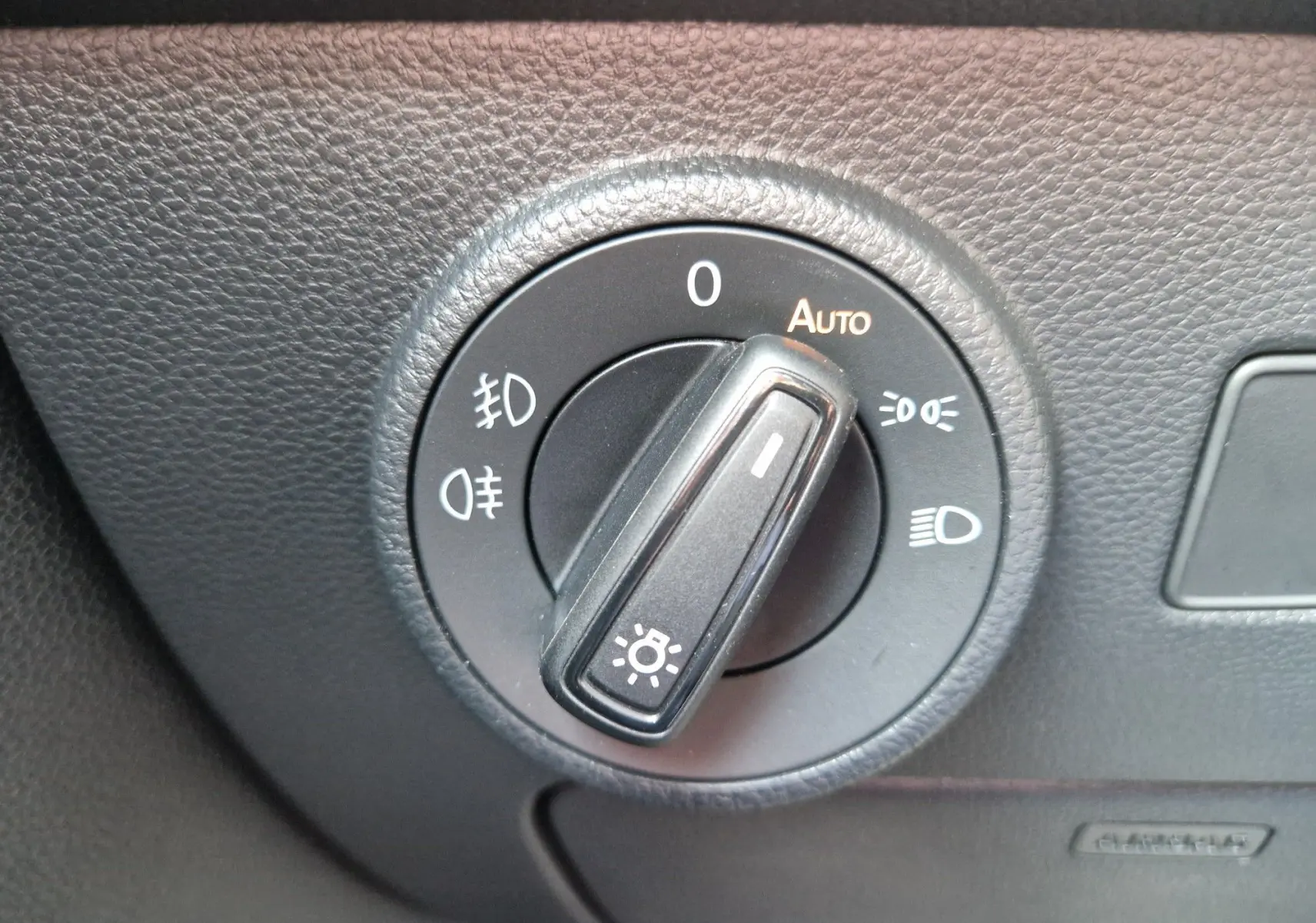 Gros plan sur le sélecteur de phares du tableau de bord noir du SEAT Ateca 2.0 TDI 150 CH DSG7 2023.