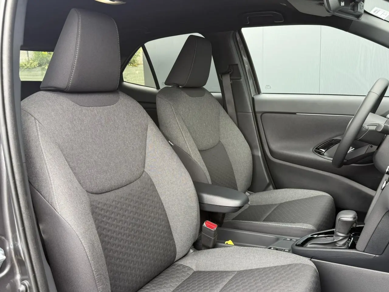 Vue intérieure côté droit montrant les sièges avant gris et la console centrale de la Toyota Yaris Cross 2026.
