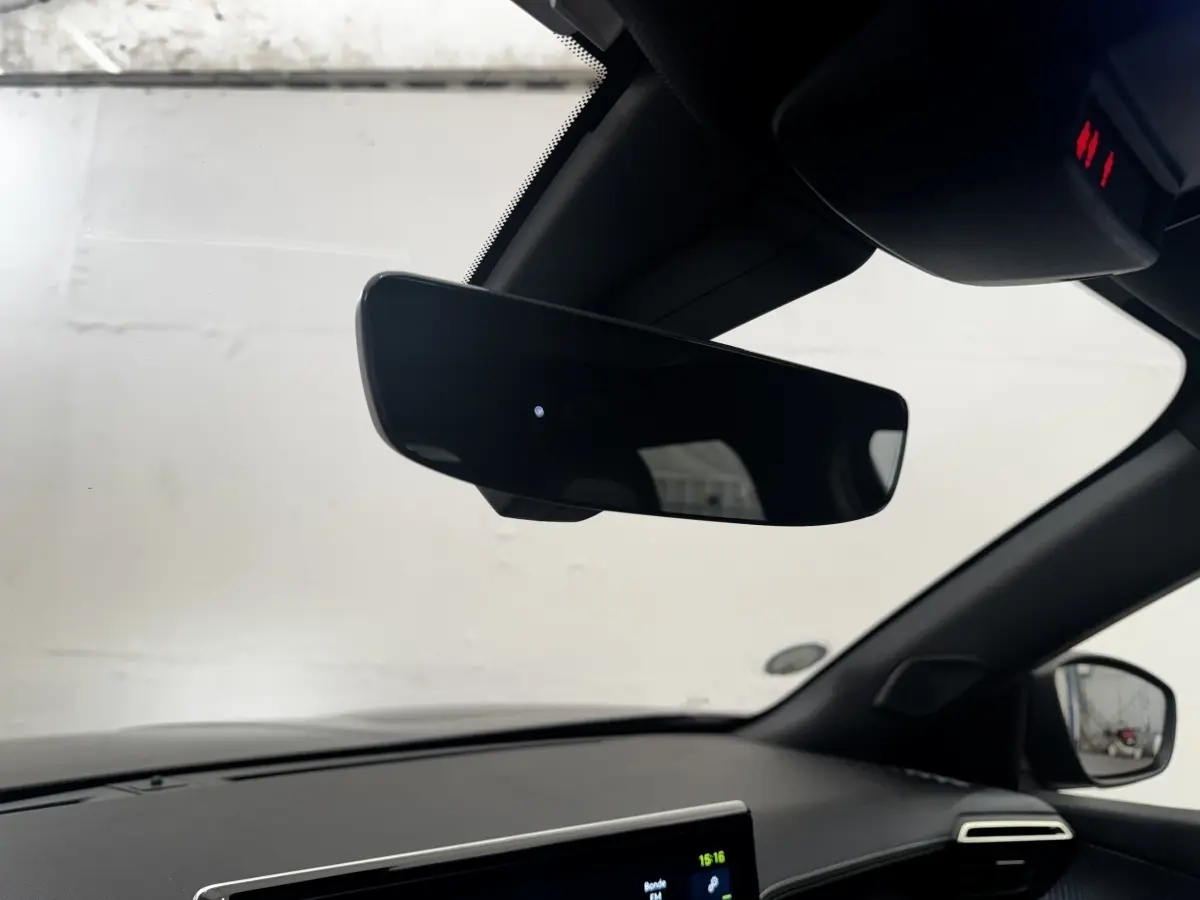 Vue intérieure du tableau de bord et rétroviseur noir du Peugeot E-2008 électrique GT Pack 2021, côté droit.