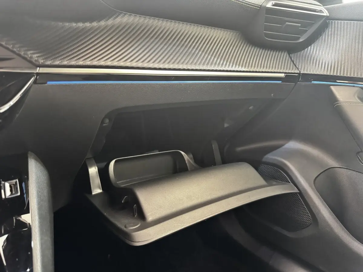 Vue intérieure côté passager du Peugeot E-2008 GT Pack électrique 2021, montrant la boîte à gants ouverte et le tableau de bord noir.
