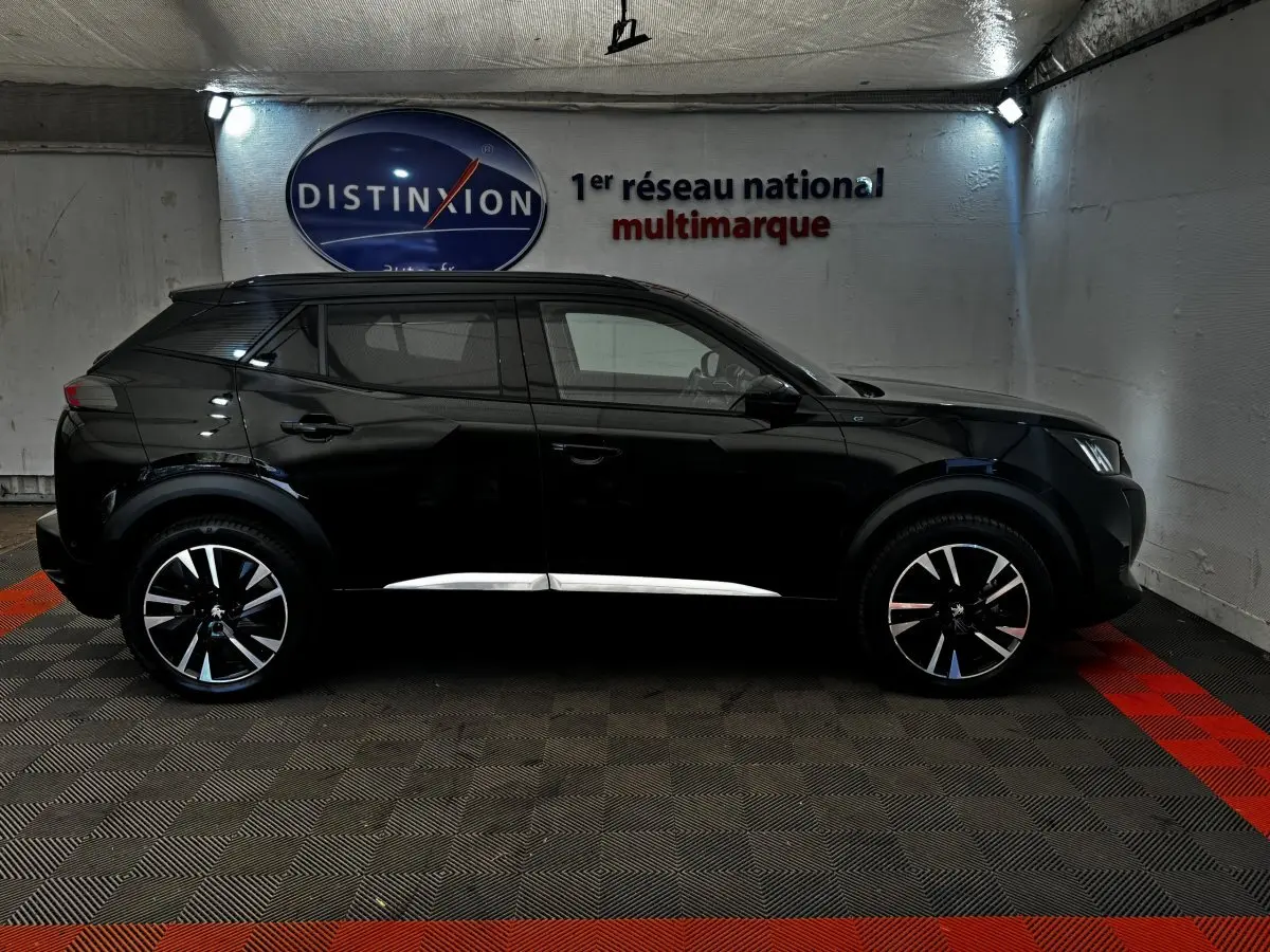 Peugeot E-2008 électrique GT Pack noir vue de profil côté gauche, jantes alliage distinctives, intérieur visible.