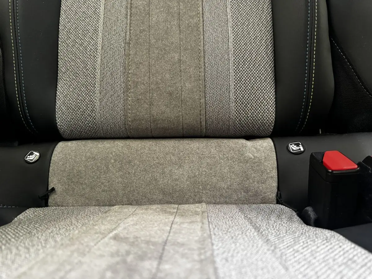 Gros plan sur la banquette arrière grise du Peugeot E-2008 électrique GT Pack avec attaches Isofix visibles.