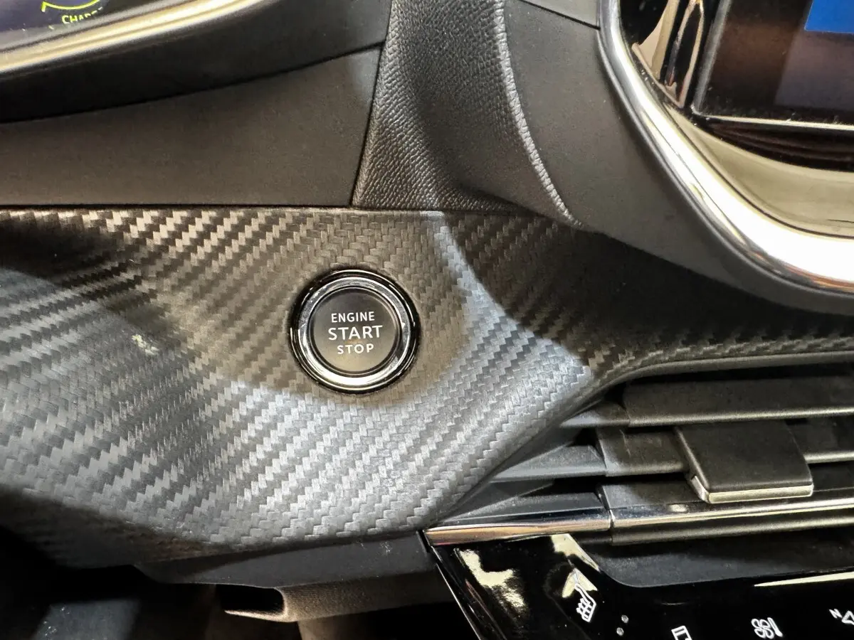Bouton démarrage moteur sur tableau de bord noir effet carbone du Peugeot E-2008 électrique GT Pack.