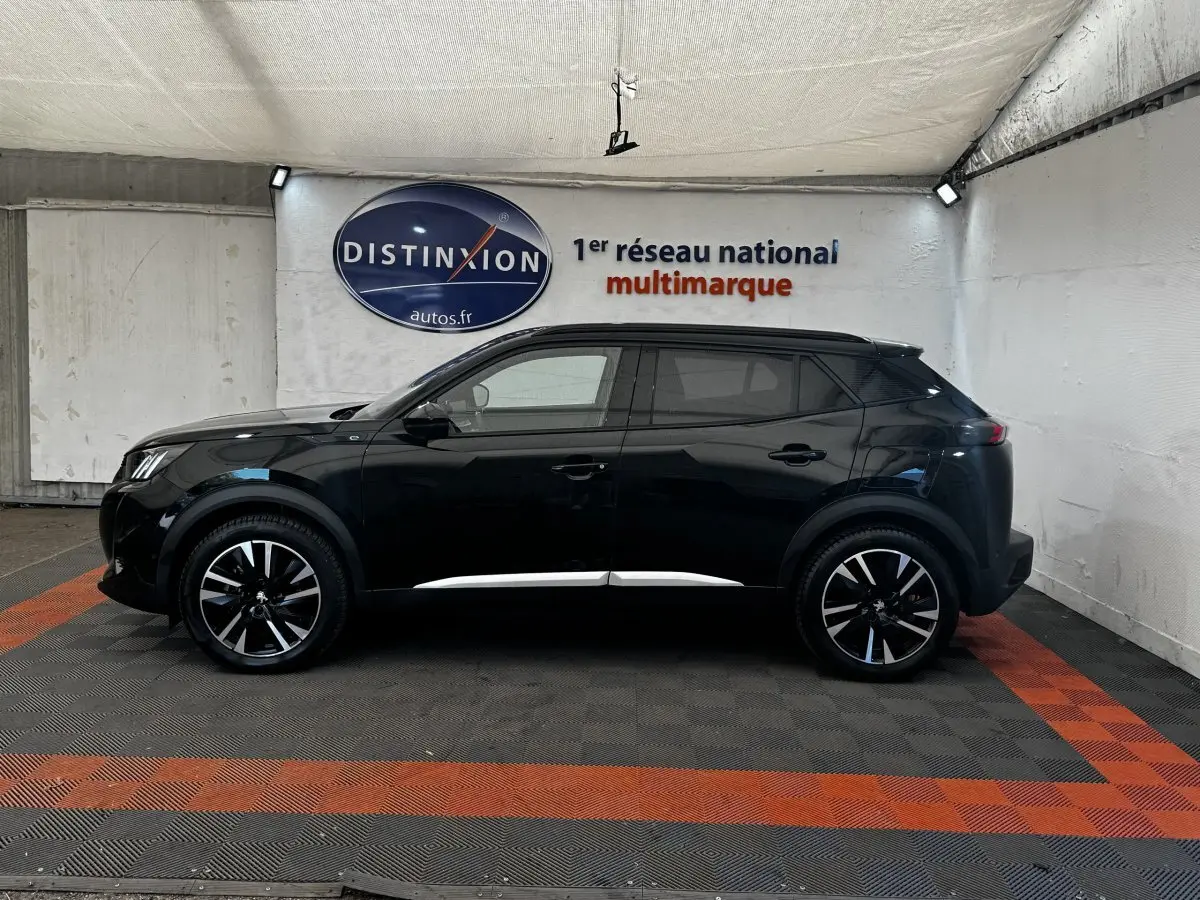 Peugeot E-2008 électrique GT Pack noir vu de profil côté gauche, avec jantes noires et détails chromés.