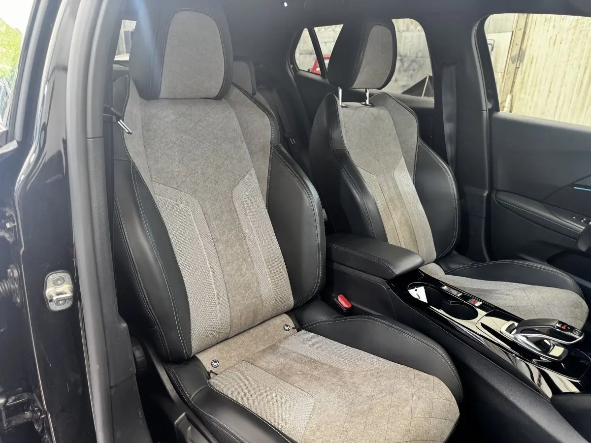 Vue intérieure des sièges avant en tissu gris et cuir noir du Peugeot E-2008 électrique GT Pack 2021, côté droit.