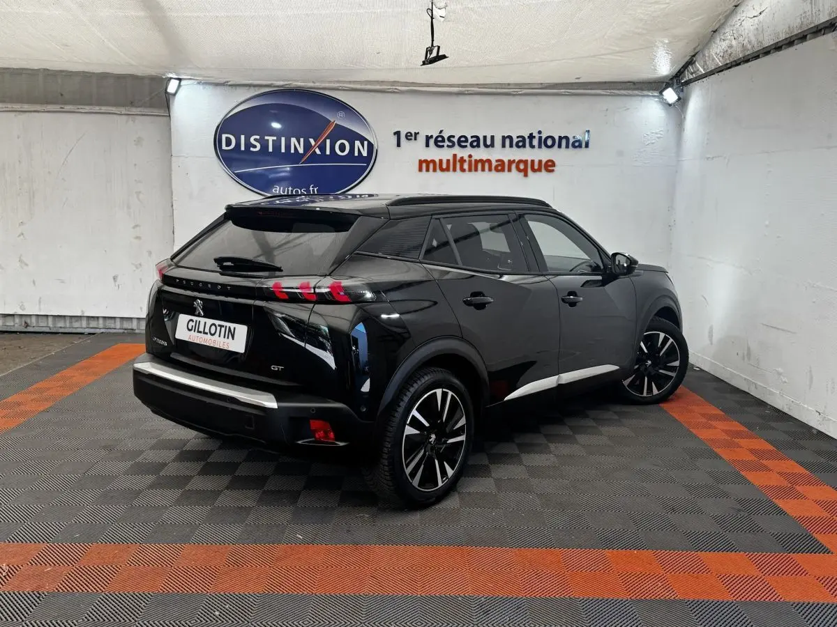 Peugeot E-2008 électrique GT Pack noir, vue 3/4 arrière droit, jantes alliage et feux arrière LED distinctifs.