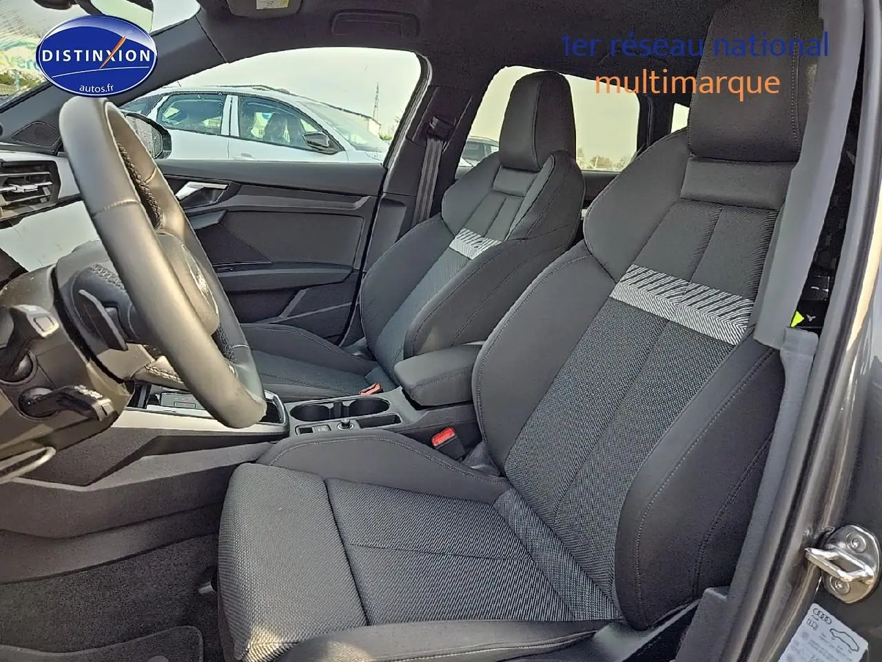 Intérieur de l'Audi A3 Sportback 2024 en gris Daytona, vue côté gauche sur les sièges avant sport avec accoudoir central.