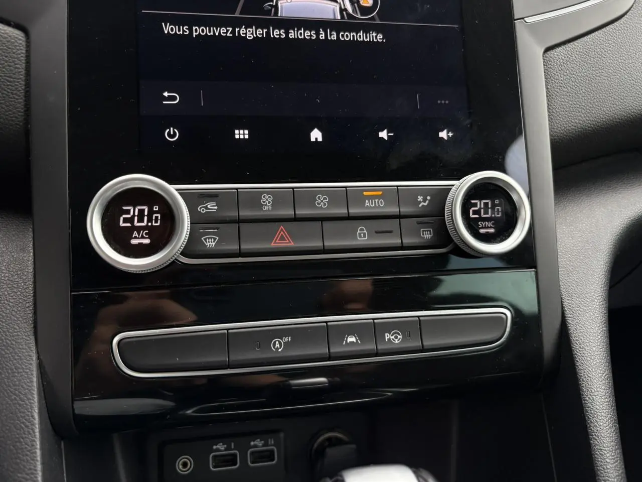 Vue rapprochée du tableau de bord central de la Renault Mégane Break 2024, avec commandes climatisation digitale à 20°C et écran tactile Easy Link.