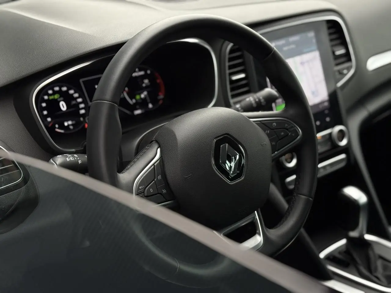 Intérieur de la Renault Mégane Break 2024, vue du volant cuir Soft Touch et écran tactile GPS EasyLink 9,3 pouces.