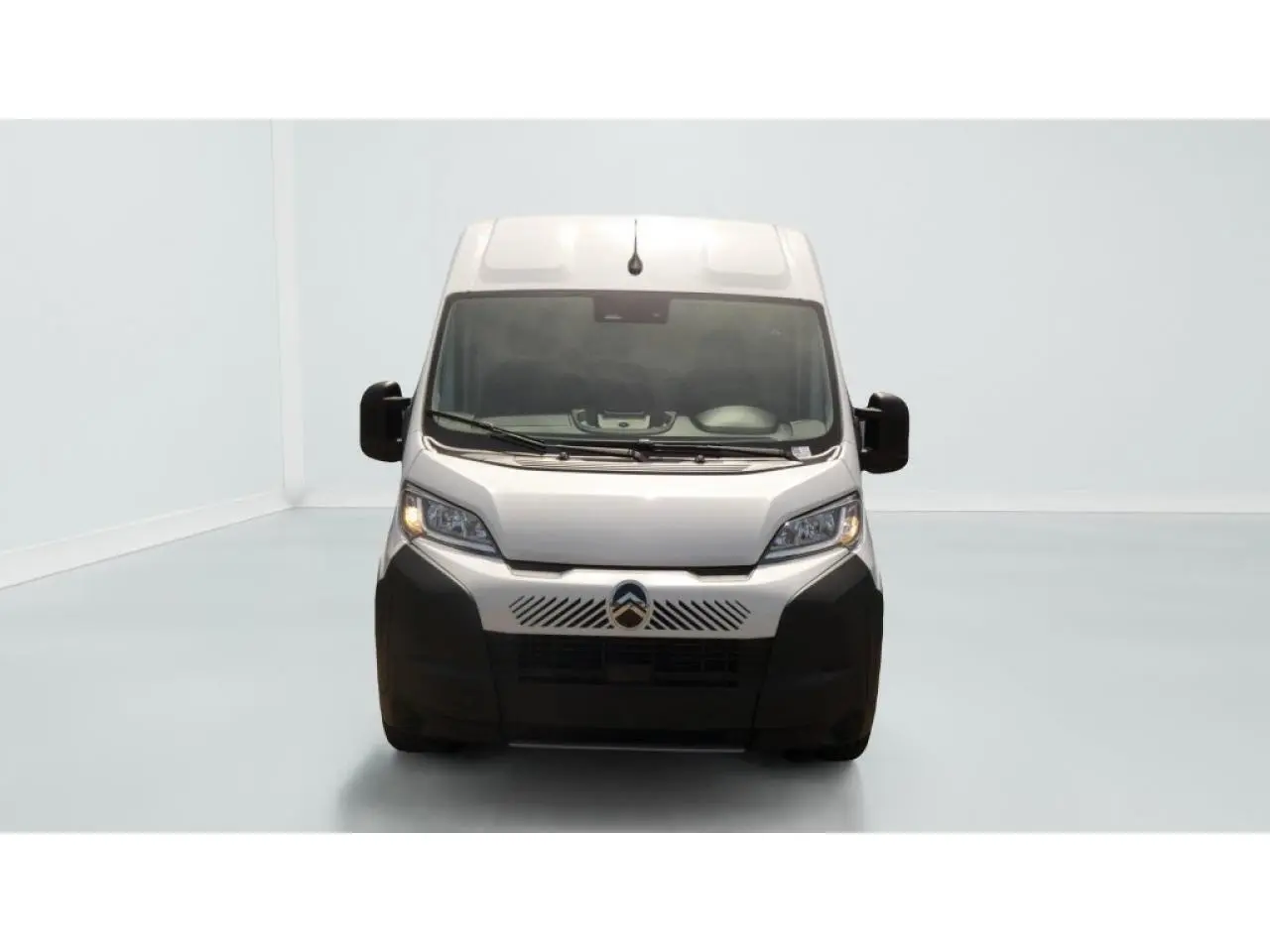 Vue frontale du Citroën Jumper blanc 2025 avec calandre noire et grands rétroviseurs latéraux noirs.