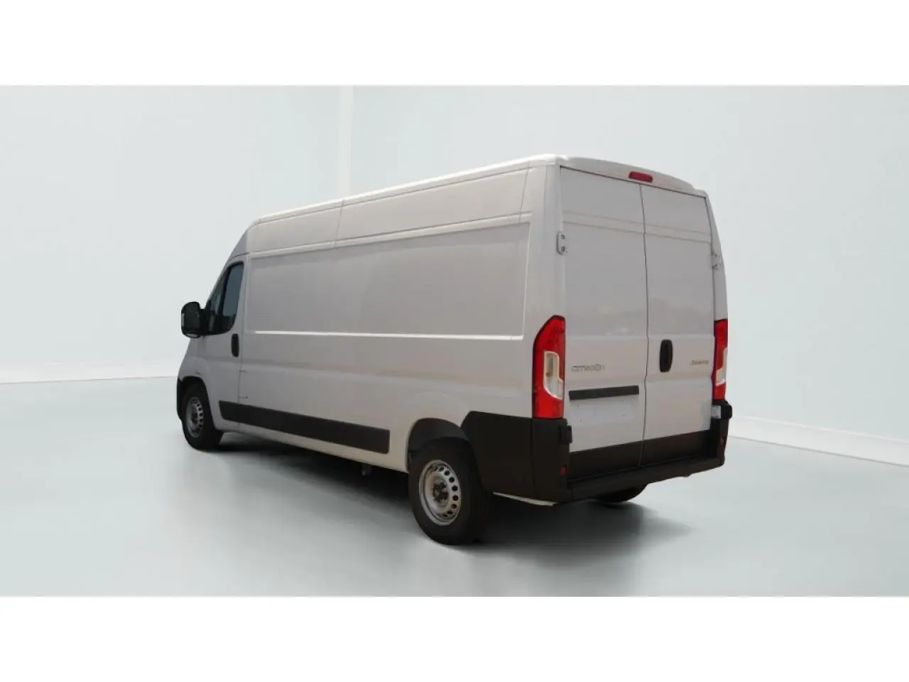 Vue 3/4 arrière droite d’un utilitaire Citroën Jumper blanc avec porte latérale coulissante et hayon arrière fermé.