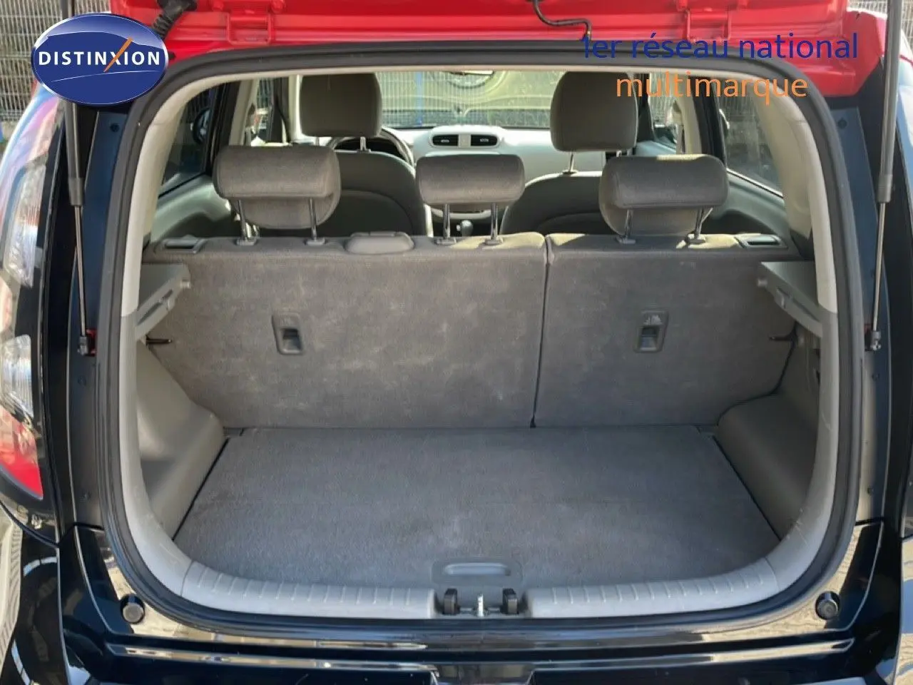 Vue arrière du coffre ouvert d'une KIA SOUL EV électrique noire Shadow Metal avec intérieur gris.