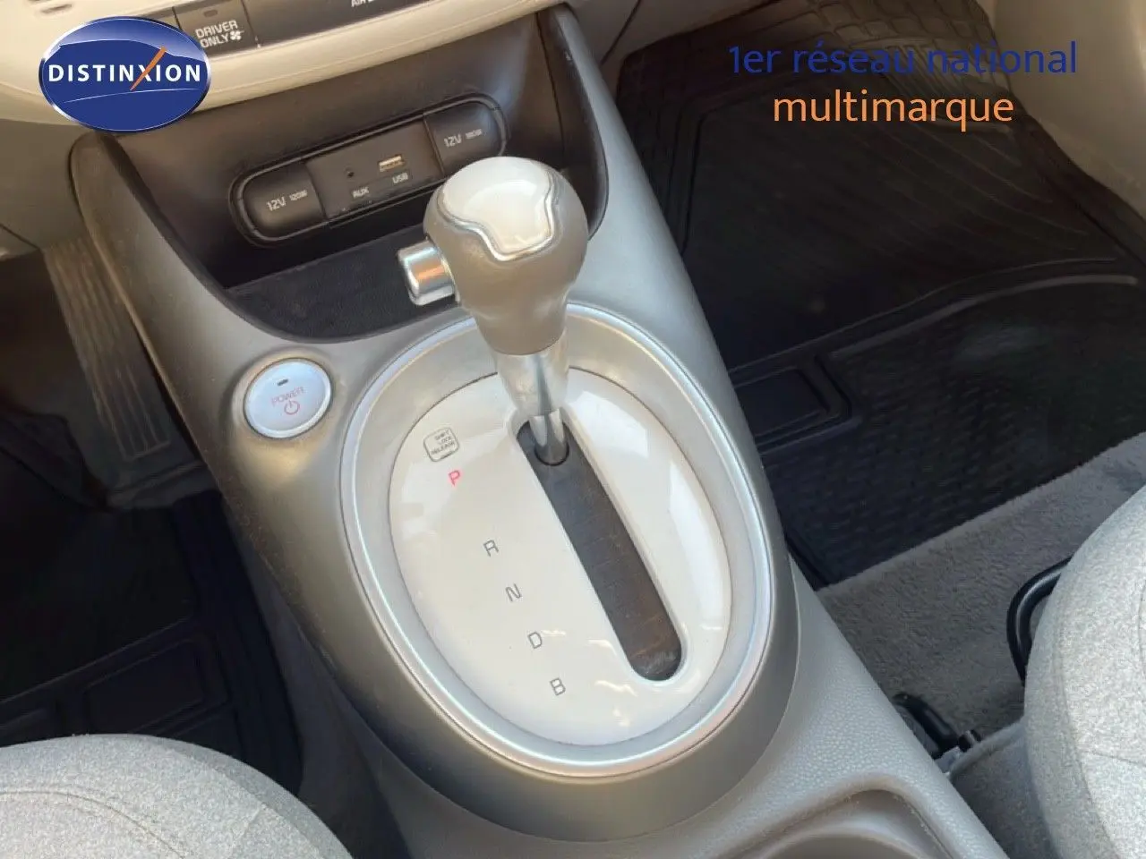 Gros plan sur la console centrale de la Kia Soul EV 2016, montrant le levier de vitesses automatique et le bouton power.