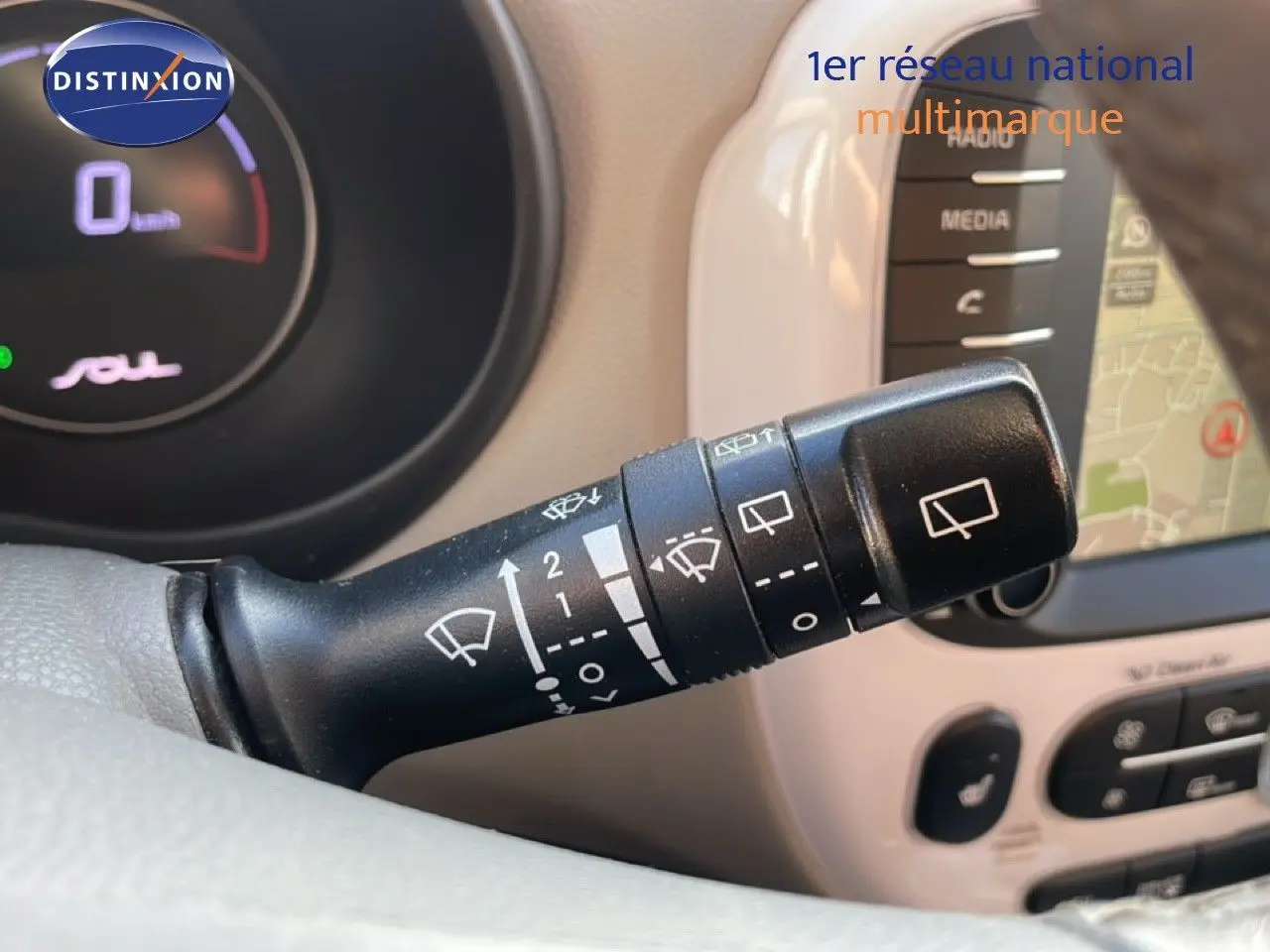 Gros plan sur la manette d'essuie-glace noire à gauche du volant dans l'habitacle clair d'une Kia Soul électrique 2016.