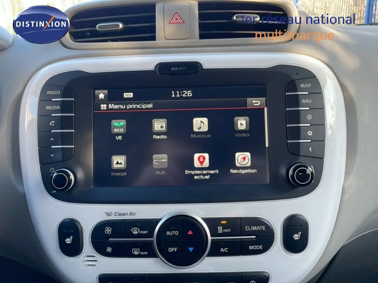 Vue rapprochée de l'écran tactile central et des commandes de climatisation du Kia Soul EV 2016 noir Shadow Metal avec toit rouge.