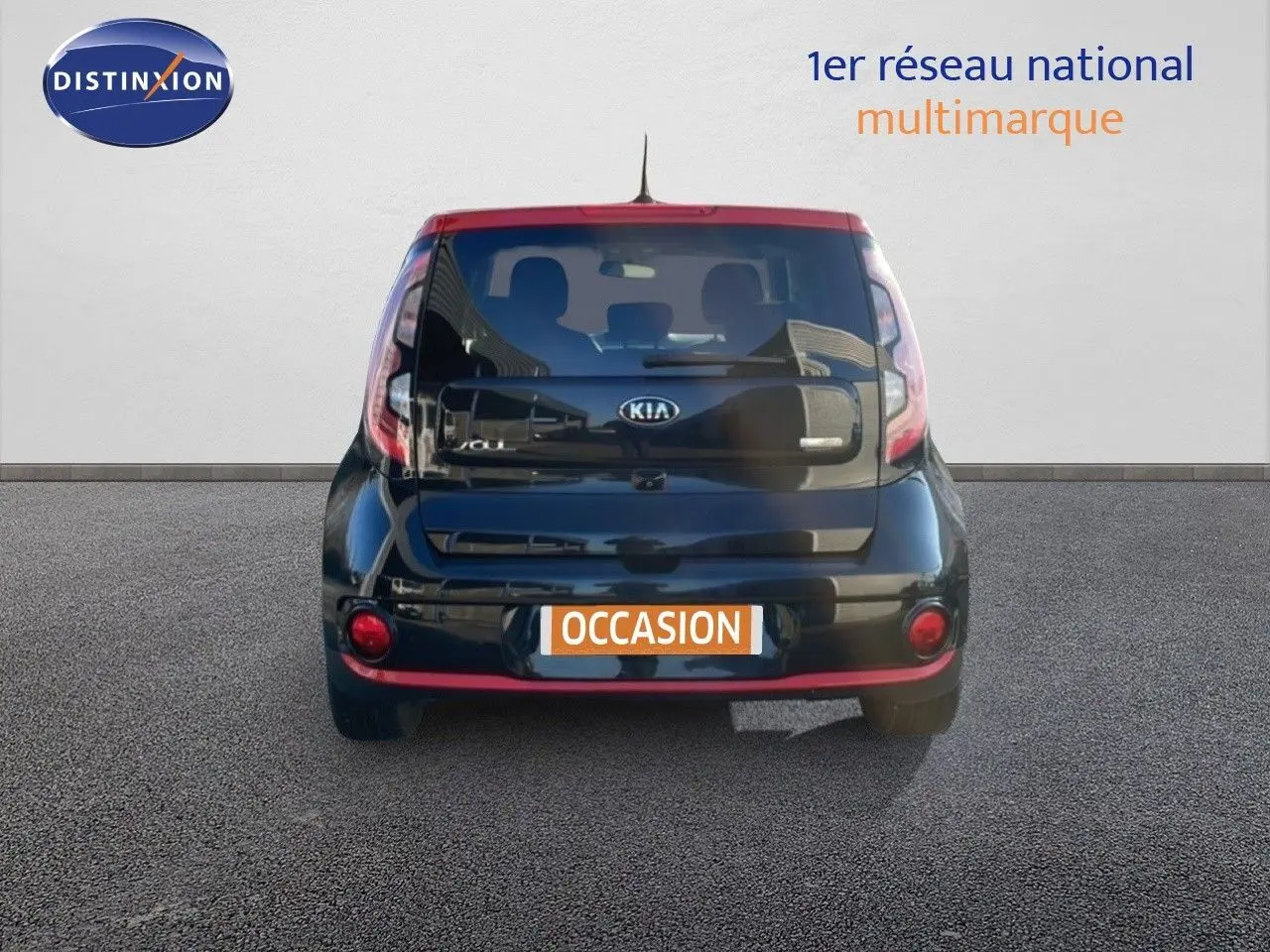 Vue arrière d'une Kia Soul EV électrique 2016 noire Shadow Metal avec toit rouge et détails rouges au bas du pare-chocs.