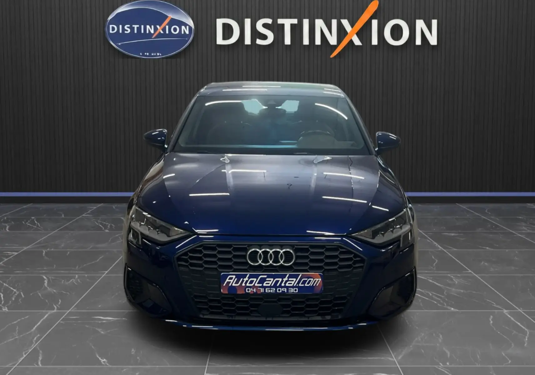 Vue frontale d'une Audi A3 Sportback bleu métallisé 2021, avec calandre hexagonale et logo Audi bien visibles.