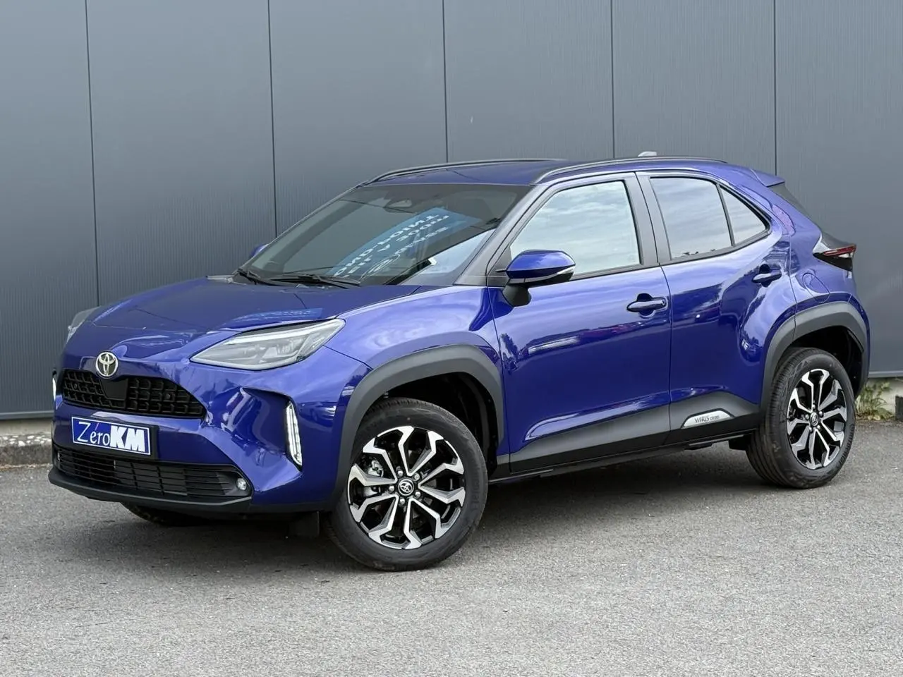 Toyota Yaris Cross 2026 bleu Genievre en 3/4 avant droit avec jantes alliage et protections noires.