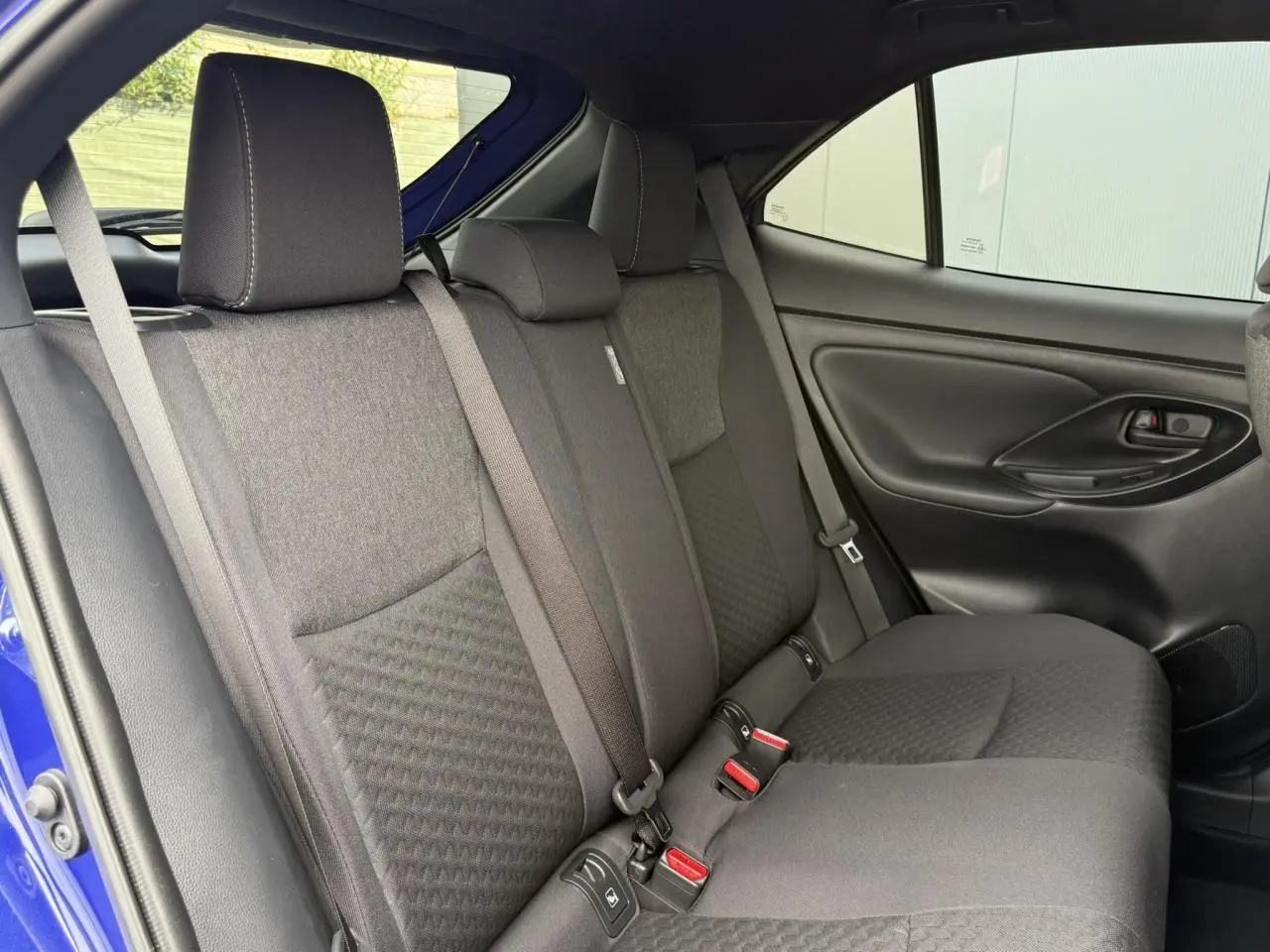 Vue intérieure côté droit des sièges arrière noirs du Toyota Yaris Cross 1.5 Hybrid 2026 Bleu Genievre.