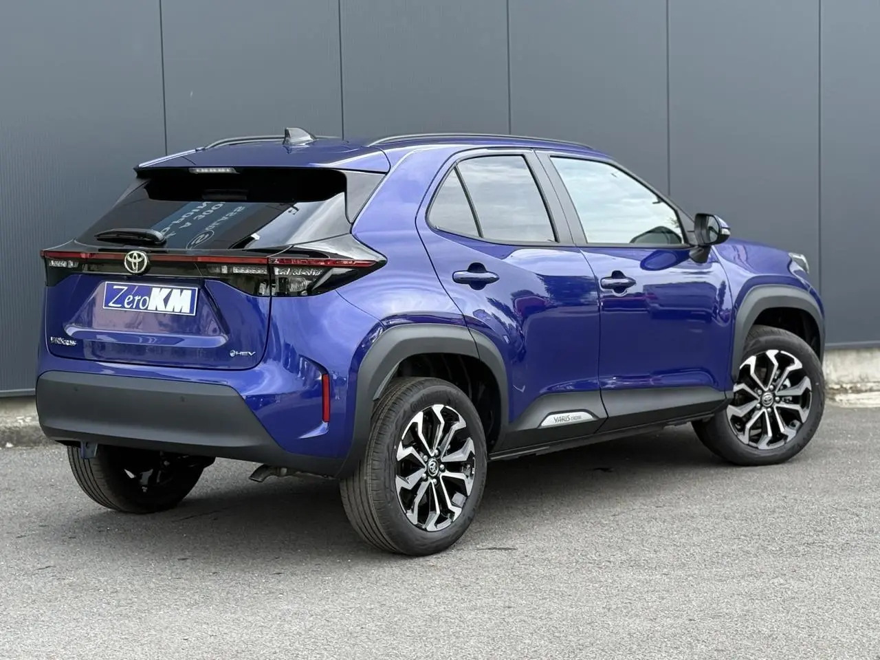 Vue 3/4 arrière droite d'une Toyota Yaris Cross bleu Genievre avec jantes alliage et toit noir contrasté.