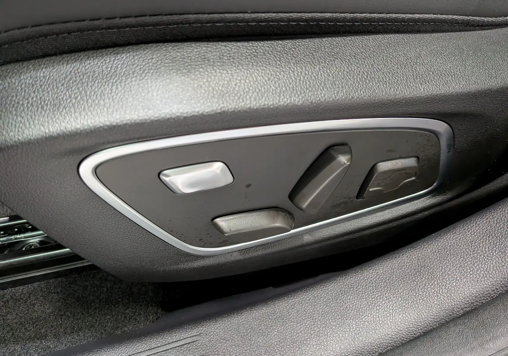 Détail des commandes de réglage électrique du siège côté gauche, sur Renault Austral noir 2026.
